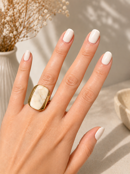 Anillo Eterna de acero dorado con piedra de vetas naturales, diseño ajustable, sobre fondo neutro