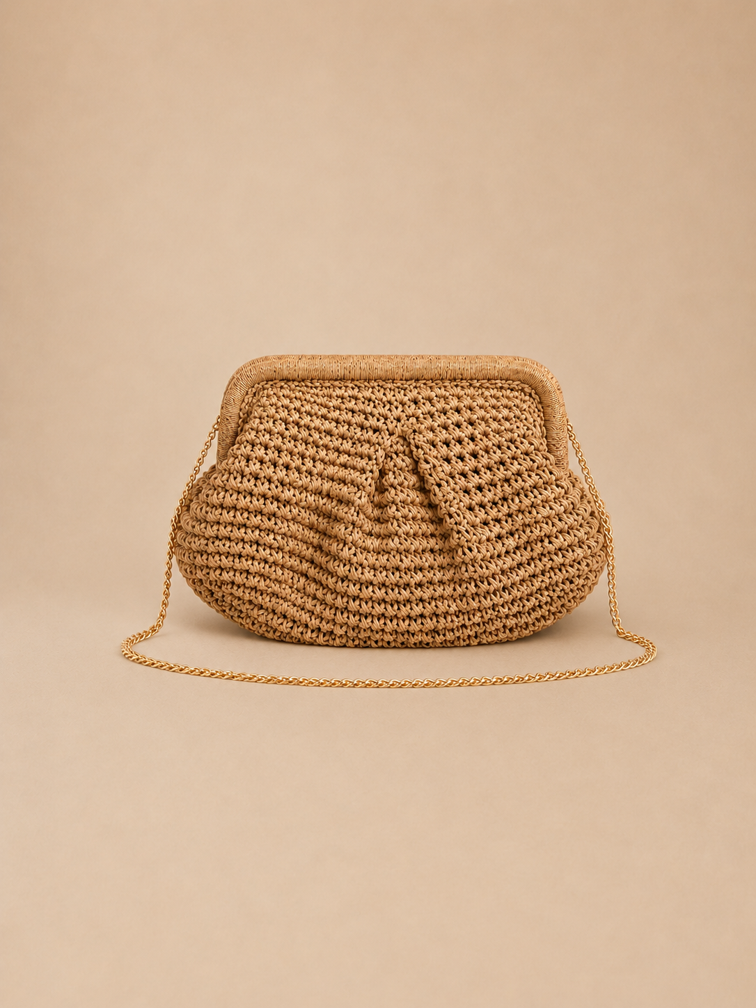 Bolso Bali de rafia trenzada a mano en tono beige natural, con asa de cadena metálica dorada,