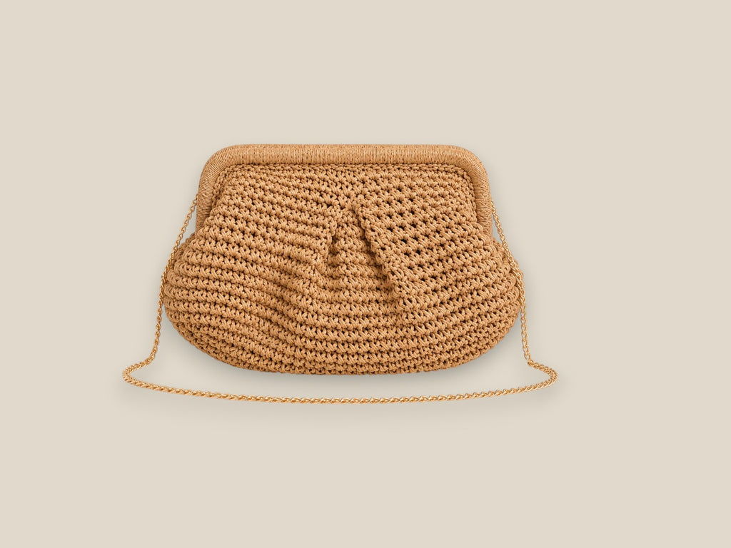 Bolso Bali de rafia trenzada a mano en tono beige natural, con asa de cadena metálica dorada, sobre fondo blanco