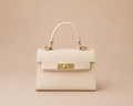 Bolso Kelly beige de piel estructurado con asa corta y detalles metálicos dorados, vista frontal 100%