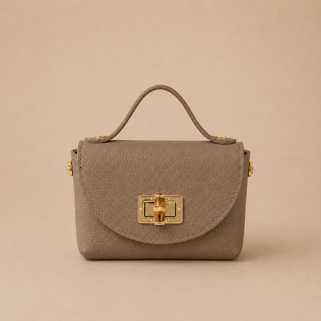 Bolso de piel taupe con solapa redondeada, broche metálico dorado y detalle
