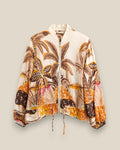 Bomber Oasis de Quiérete Muxo en estampado tropical de palmeras, tonos naranja y marron sobre base crudo.