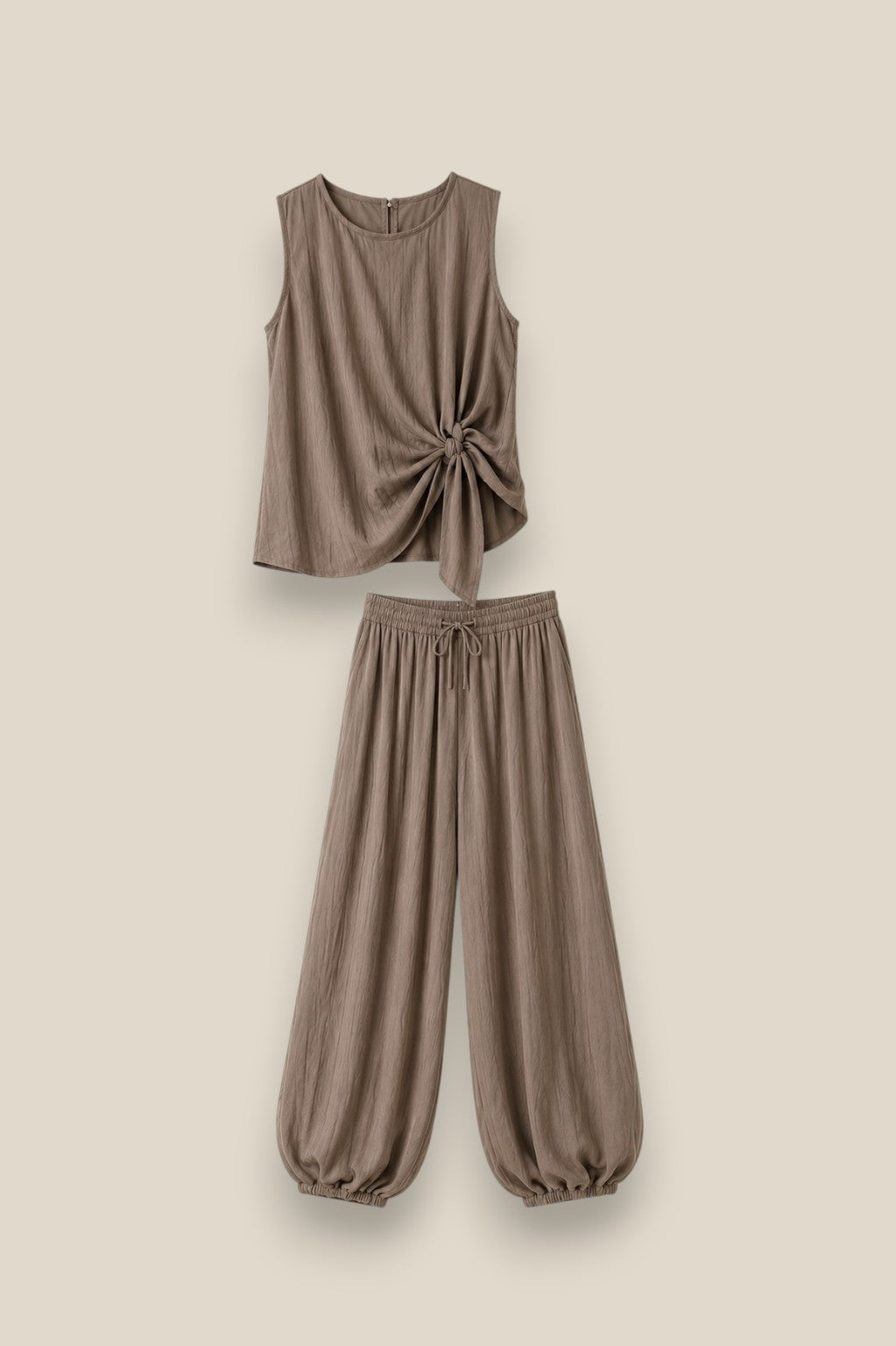 Conjunto SORA en color taupe: top sin mangas con lazada lateral y pantalón bombacho de tela fluida. Talla única S-XL.