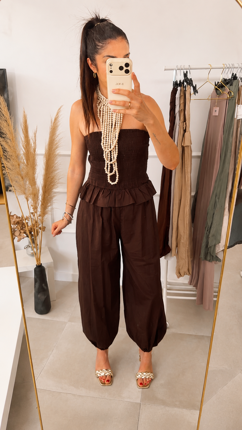 Modelo con Mono Kenia marrón chocolate, top bandeau fruncido sin tirantes y pantalón harem abullonado, vista frontal