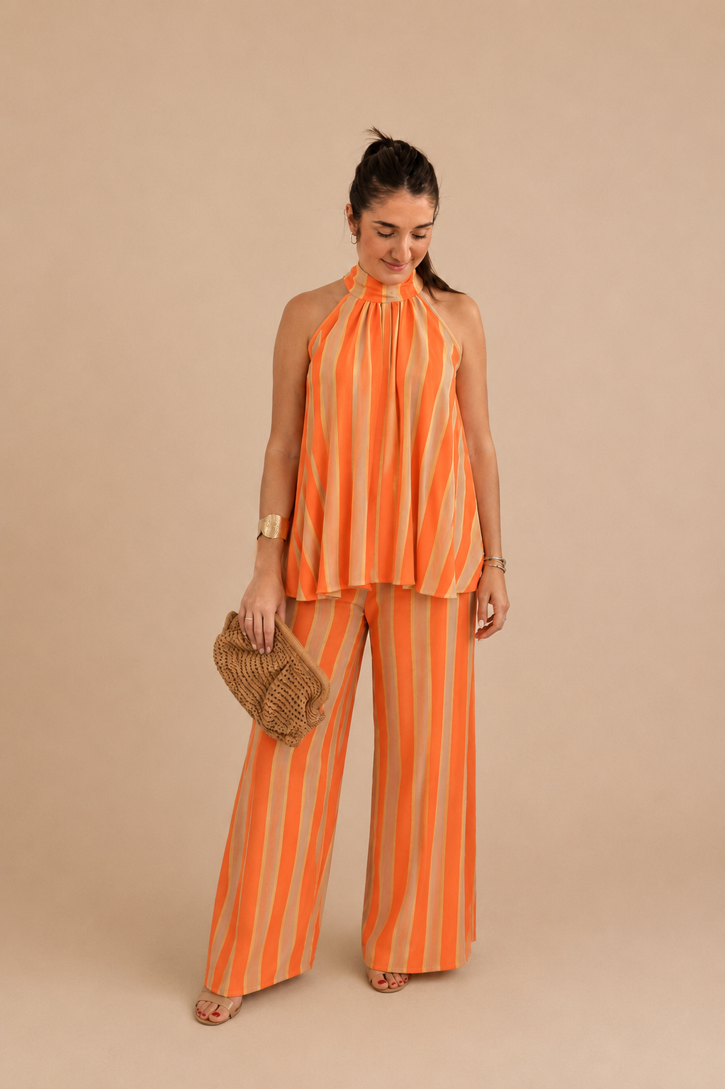 Modelo con el Conjunto Bali de rayas naranja y arena, top halter y pantalón ancho, 