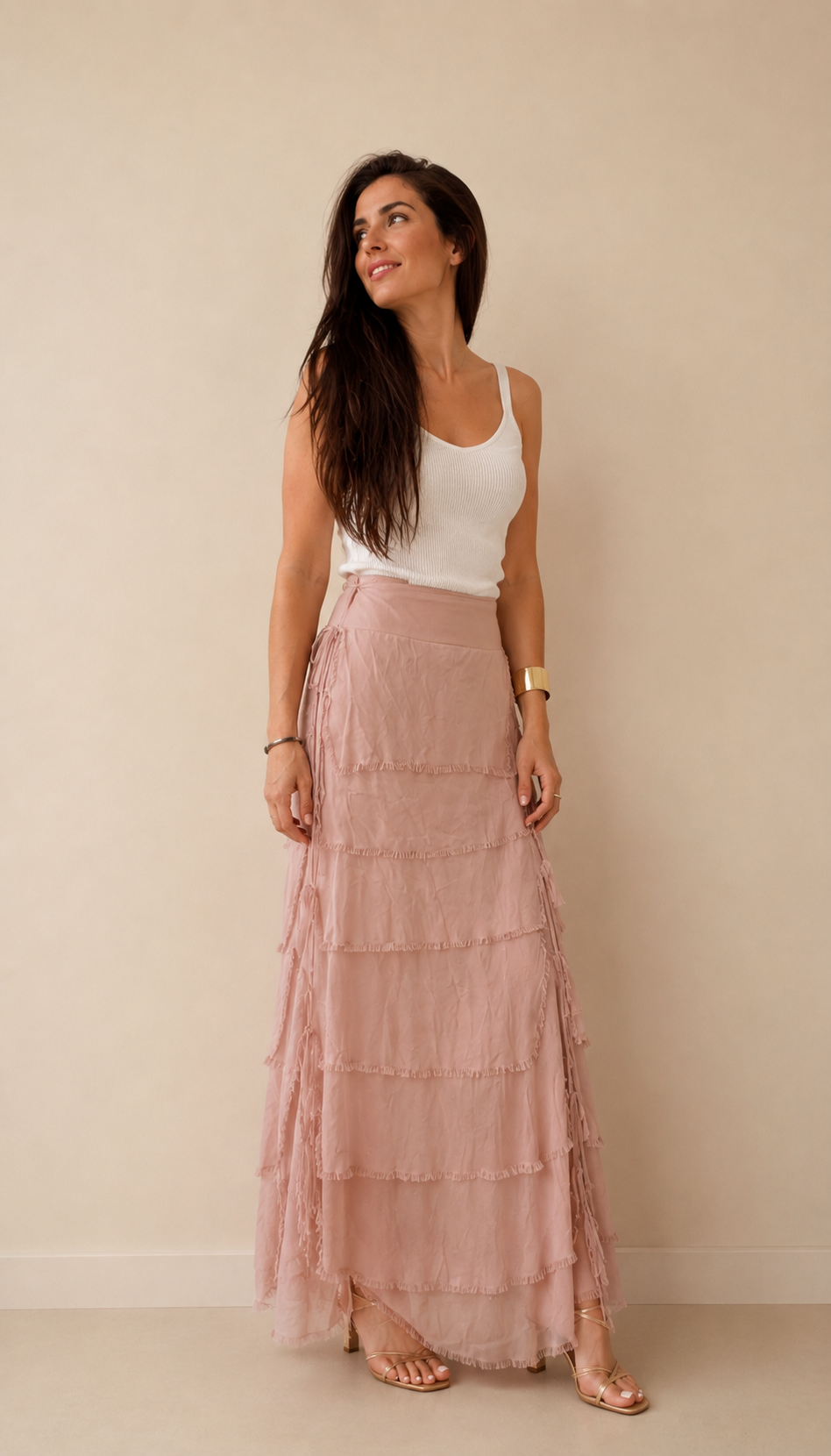 Modelo con falda larga de volantes en seda natural beige, vista frontal, mostrando la caída y elegancia de la prenda