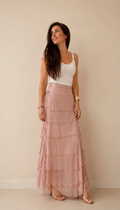 Modelo con falda larga de volantes en seda natural beige, vista frontal, mostrando la caída y elegancia de la prenda