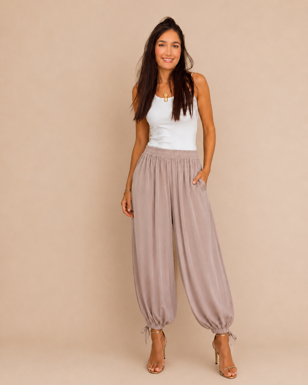 Modelo con pantalón bombacho satinado lazada rosa, vista frontal