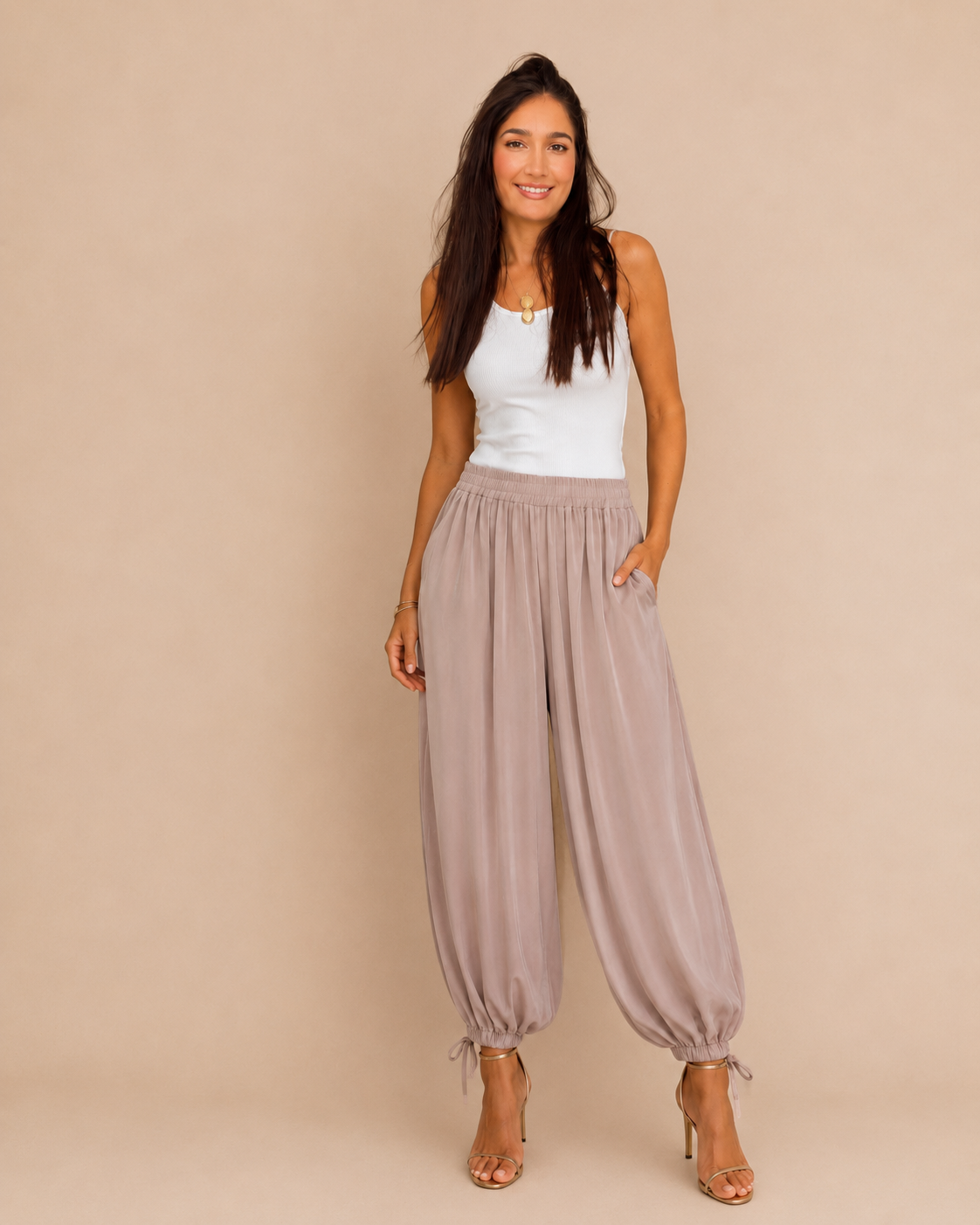 Modelo con pantalón bombacho satinado lazada rosa, vista frontal