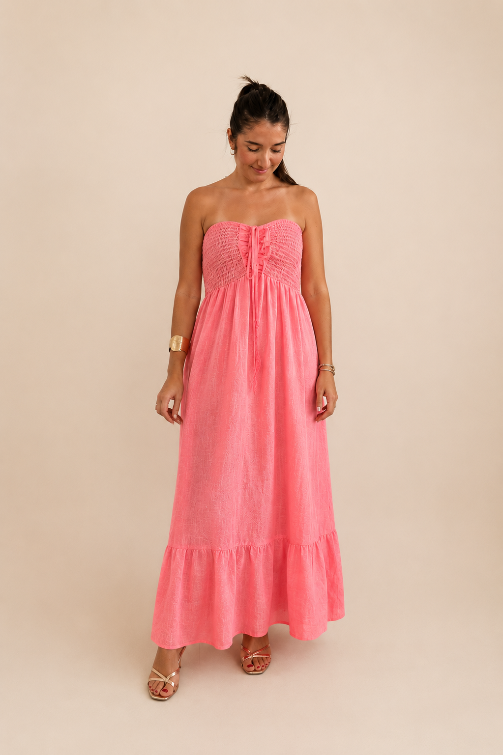 Modelo con vestido en lino 100% color flúor coral y pecho en palabra de honor y espalda fruncida de quiérete muxo 
