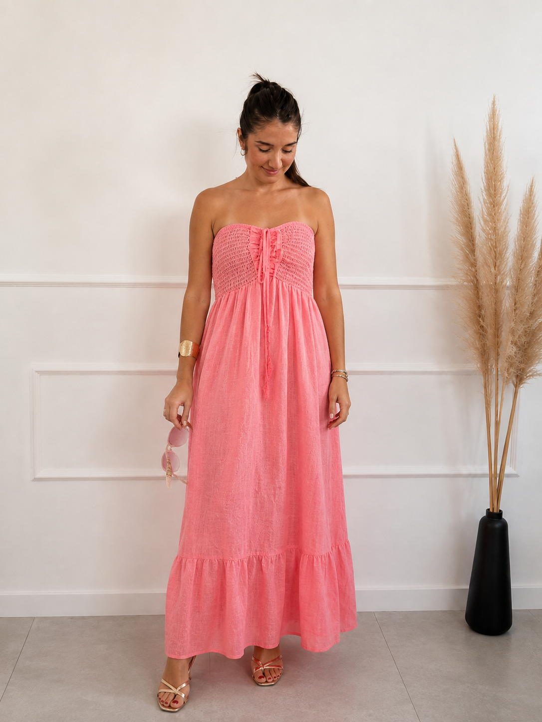 Modelo con vestido en lino 100% color flúor coral y pecho en palabra de honor y espalda fruncida de quiérete muxo  by esenzia