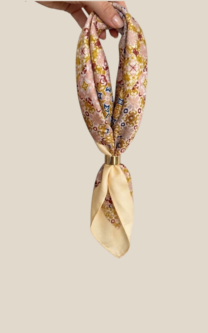 Pañuelo de seda amarillo para el cuello Quiérete, con estampado exclusivo y anilla dorada.