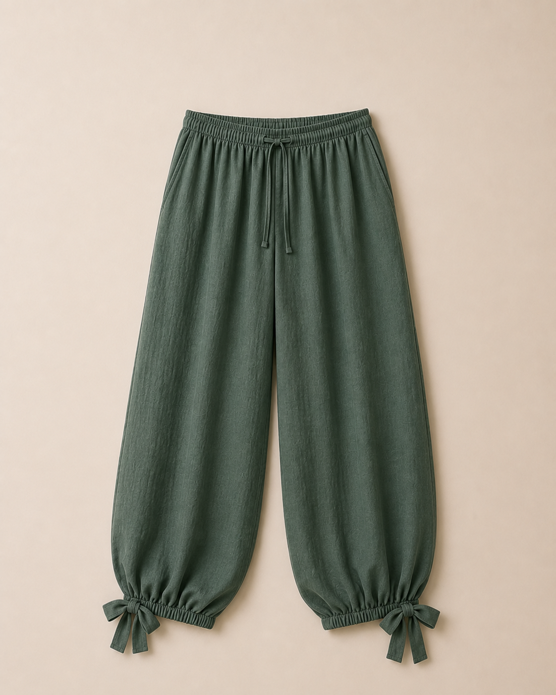 Pantalón bombacho de lino en color verde topo con cintura elástica, lazadas ajustables en el bajo y tejido ligero de estilo mediterráneo