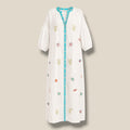 Vestido Océano blanco de Quiérete Muxo con bordados marinos de coral, conchas y peces en verde y turquesa.