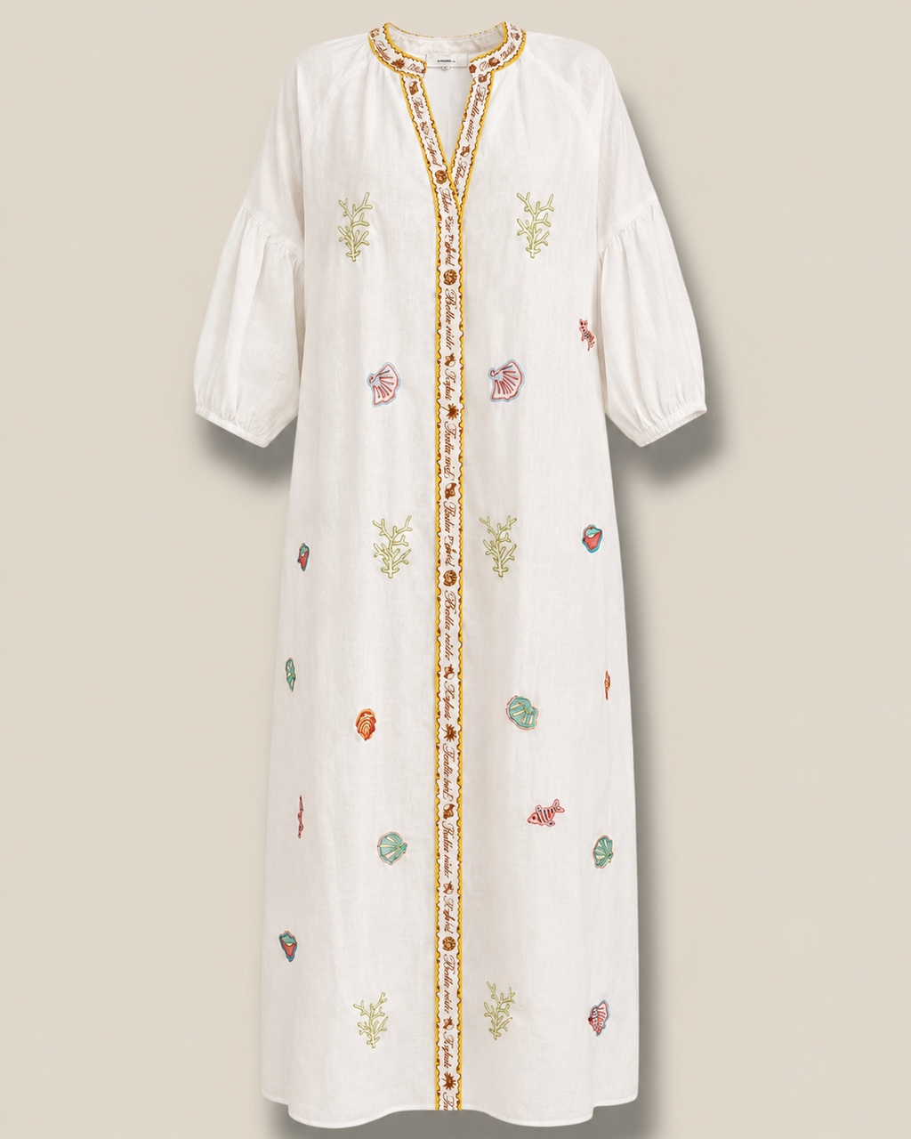 Vestido Océano blanco de Quiérete Muxo con bordados marinos de coral, conchas y peces en verde y turquesa.