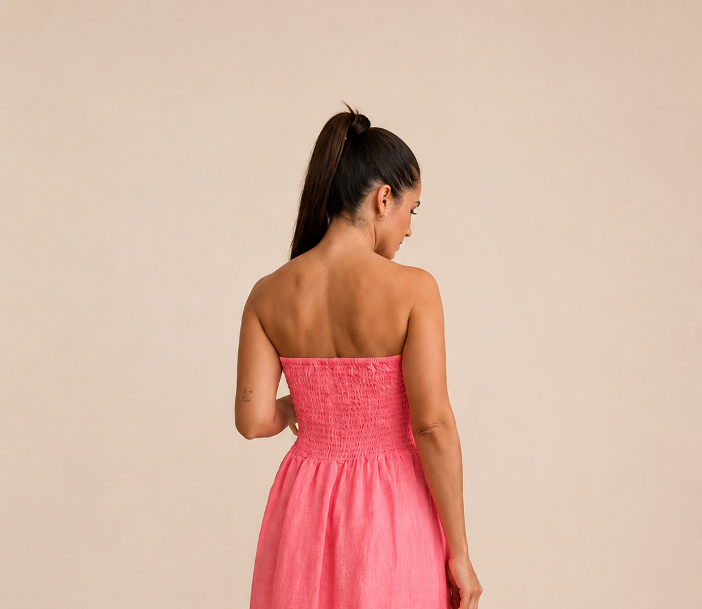 espalda de Modelo con vestido en lino 100% color flúor coral y pecho en palabra de honor y espalda fruncida de quiérete muxo 